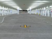 a parking lot with lots of empty parking lots and yellow arrows indicating a pointy exit