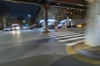 cars and trucks drive down the street next to an urban bridge at night time,