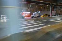 cars and trucks drive down the street next to an urban bridge at night time,