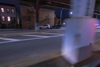 cars and trucks drive down the street next to an urban bridge at night time,