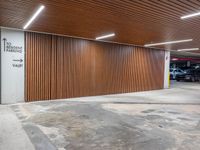 an open car parking garage with wooden slats and doors and a ramp for vehicles