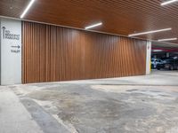 an open car parking garage with wooden slats and doors and a ramp for vehicles