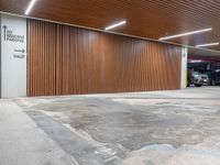 an open car parking garage with wooden slats and doors and a ramp for vehicles