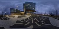 a circular image of an office building at night time with people walking and cycling around it