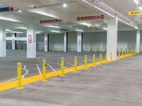 the interior of a large building is empty, filled with parking meters, yellow poles and safety barriers