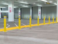 the interior of a large building is empty, filled with parking meters, yellow poles and safety barriers