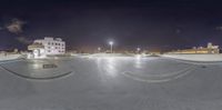 a view from a ramp of a parking lot at night time with lights on and the sky and buildings