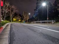 a very empty street and no cars on it at night, with a traffic signal