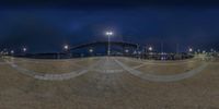 a skateboarder is riding down the street at night time, and looks at the bridge