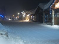 night time in a small town with a snow covered road and building in the background