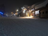 night time in a small town with a snow covered road and building in the background