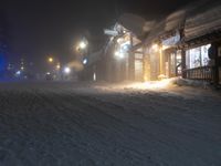 night time in a small town with a snow covered road and building in the background