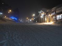 night time in a small town with a snow covered road and building in the background