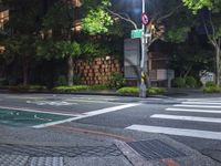 traffic lights are lit up on the side of a street with a sidewalk and bicycle lane