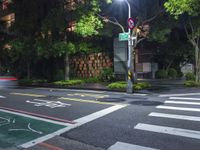 traffic lights are lit up on the side of a street with a sidewalk and bicycle lane