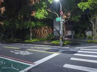 traffic lights are lit up on the side of a street with a sidewalk and bicycle lane