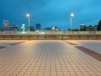 people standing on a subway platform with many buildings in the background at night light in tokyo