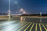 a fork lift is driving through a parking lot at night time with lights on in the background