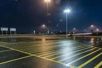 a fork lift is driving through a parking lot at night time with lights on in the background