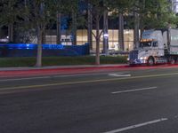 the flatbed semi truck is on the road at night time, ready to deliver