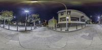 a fisheye shot showing multiple levels of pavement area at night time with street lights