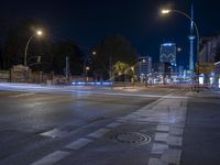 a street is busy with traffic at night, with blurry street lights illuminating the dark sky