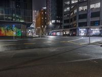 a night shot of an empty street at night in the city with lots of tall buildings