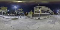 a fisheye shot showing multiple levels of pavement area at night time with street lights