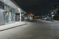 night time photograph of empty city street with lit buildings in distance in urban area at night