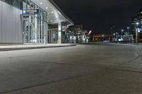 night time photograph of empty city street with lit buildings in distance in urban area at night