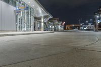 night time photograph of empty city street with lit buildings in distance in urban area at night