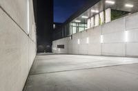 the large concrete wall has been illuminated by recessed lights at night on either side of it