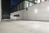 the large concrete wall has been illuminated by recessed lights at night on either side of it