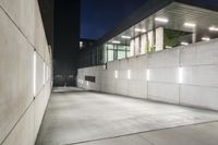 the large concrete wall has been illuminated by recessed lights at night on either side of it