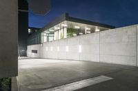 the large concrete wall has been illuminated by recessed lights at night on either side of it