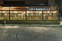 a building on a sidewalk in a neighborhood with christmas lights in the window frames outside