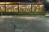 a building on a sidewalk in a neighborhood with christmas lights in the window frames outside