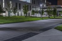 the green grass on the street is illuminated by lights of different size and shape in the buildings