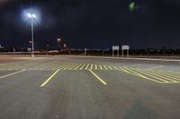 an empty parking lot with an illuminated sky in the background in a city at night