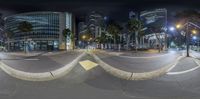 street view with traffic at night and buildings in distance in the background and the camera lens on a tripod