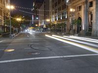 a deserted city street filled with traffic at night time at dusk, with lights on