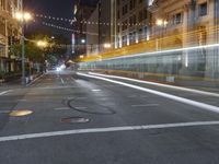 a deserted city street filled with traffic at night time at dusk, with lights on