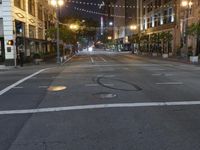 a deserted city street filled with traffic at night time at dusk, with lights on