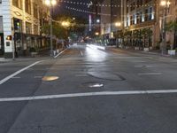 a deserted city street filled with traffic at night time at dusk, with lights on