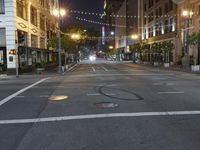 a deserted city street filled with traffic at night time at dusk, with lights on