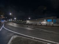 an empty street is pictured at night with long exposures of cars coming in and out