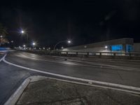 an empty street is pictured at night with long exposures of cars coming in and out