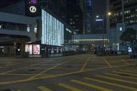 a traffic light at a busy intersection in hong city at night with pedestrians on the sidewalk