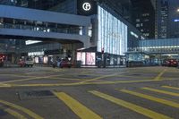 a traffic light at a busy intersection in hong city at night with pedestrians on the sidewalk
