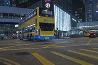 a traffic light at a busy intersection in hong city at night with pedestrians on the sidewalk
